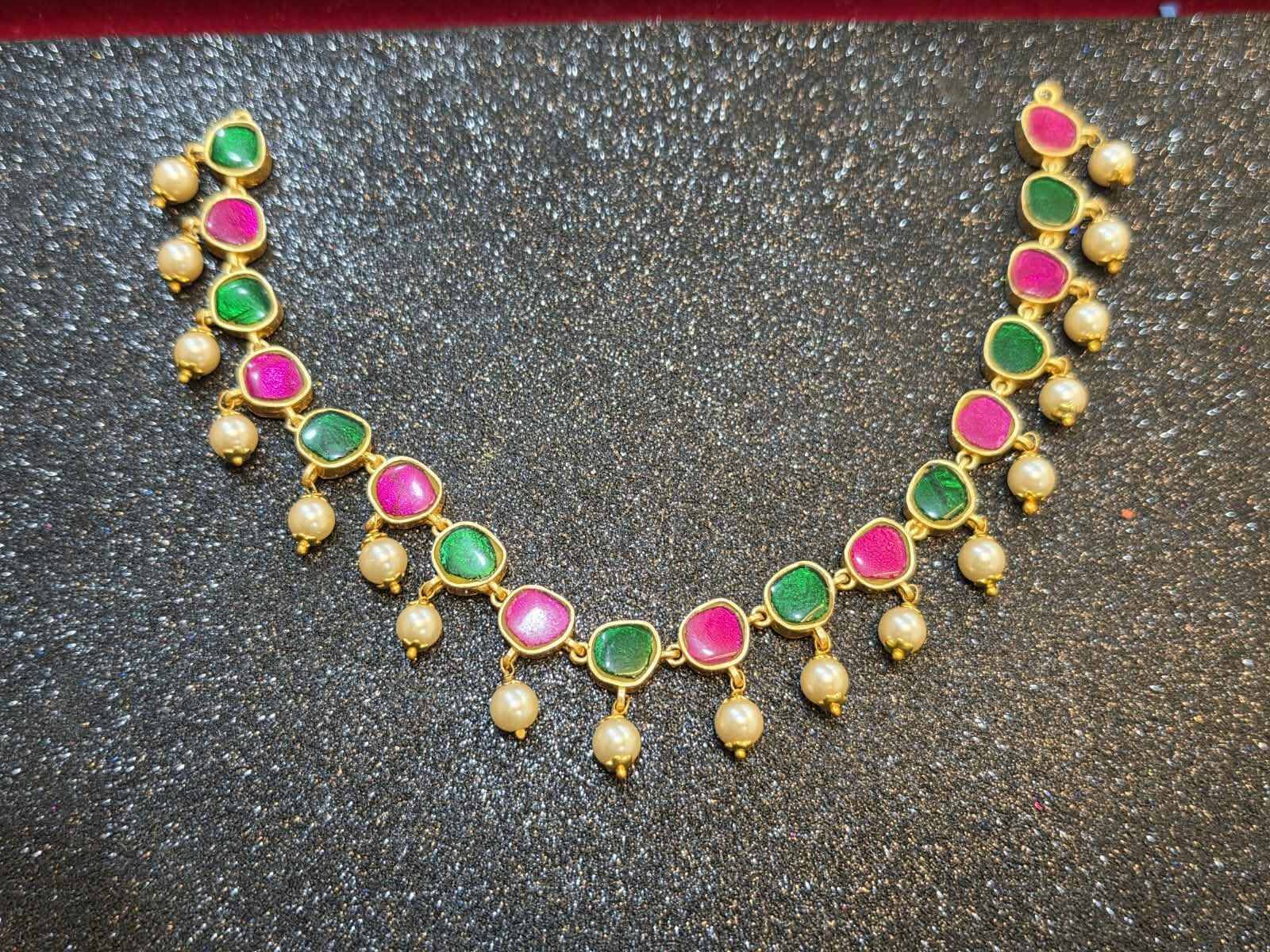 Microgold plated Jadau Kundan necklace with earrings with alternating pink and green stones, gold-tone detailing, and cream pearl drop accents.