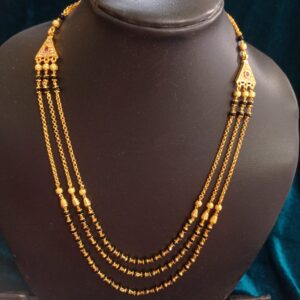 Three-layer pure Panchaloham black-bead chain with intricate gold-tone detailing, triangular motifs, and traditional red stone accents.
