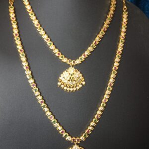 Pure Panchaloham two-layer haram with gold-tone detailing, red and green stones, clear accents, and traditional dome-shaped dangling pendants displayed on a black jewellery bust.